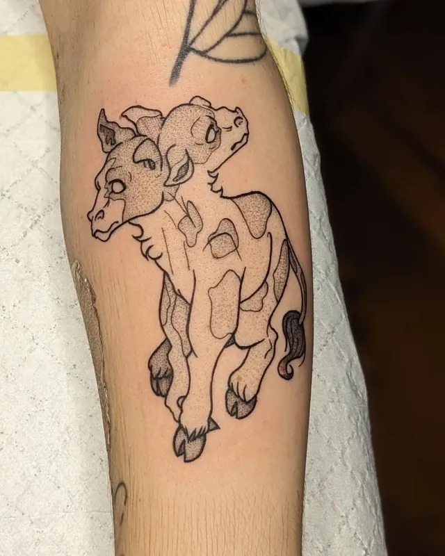 Two-headed calf linework tattoo on a forearm