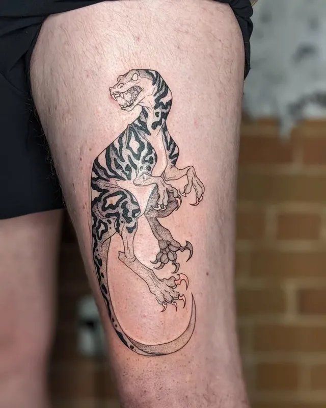 Dinosaur skeleton tattoo with tiger-stripe shading on a thigh
